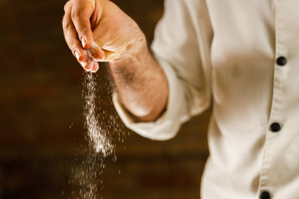 chef adding ingredients via sprinkling