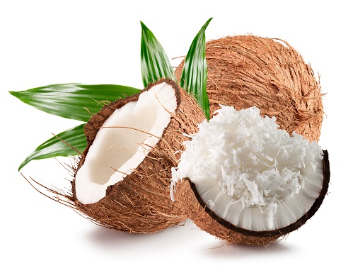 Shredded coconut on a broken coconut shell with a whole coconut and a leaf on the background