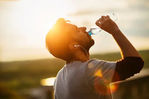 man drinking water from a bottle
