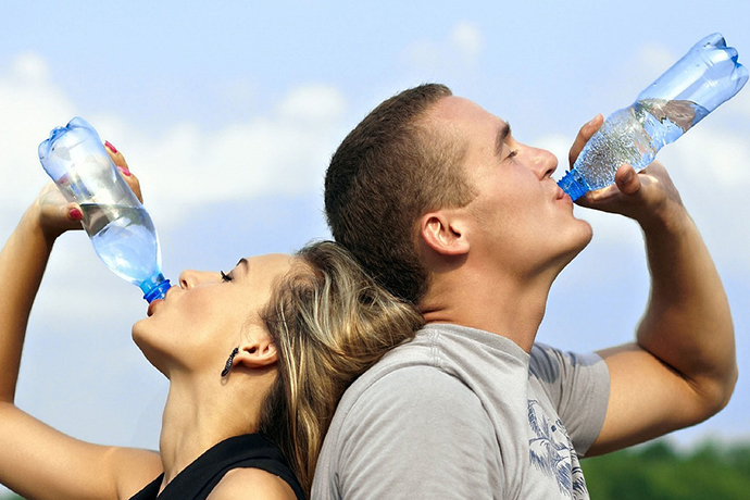 A man and woman drinking water